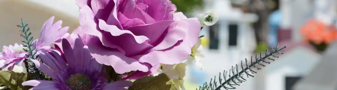 prachtvolles violettes Blumengesteck auf einem Grab