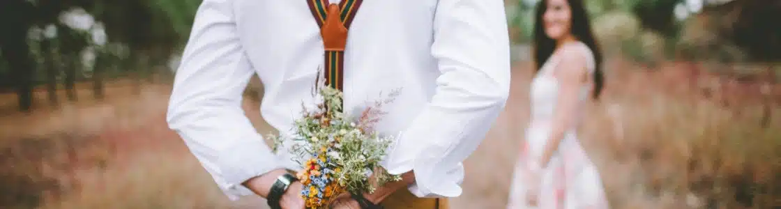 Mann überrascht Frau mit Blumenstrauß